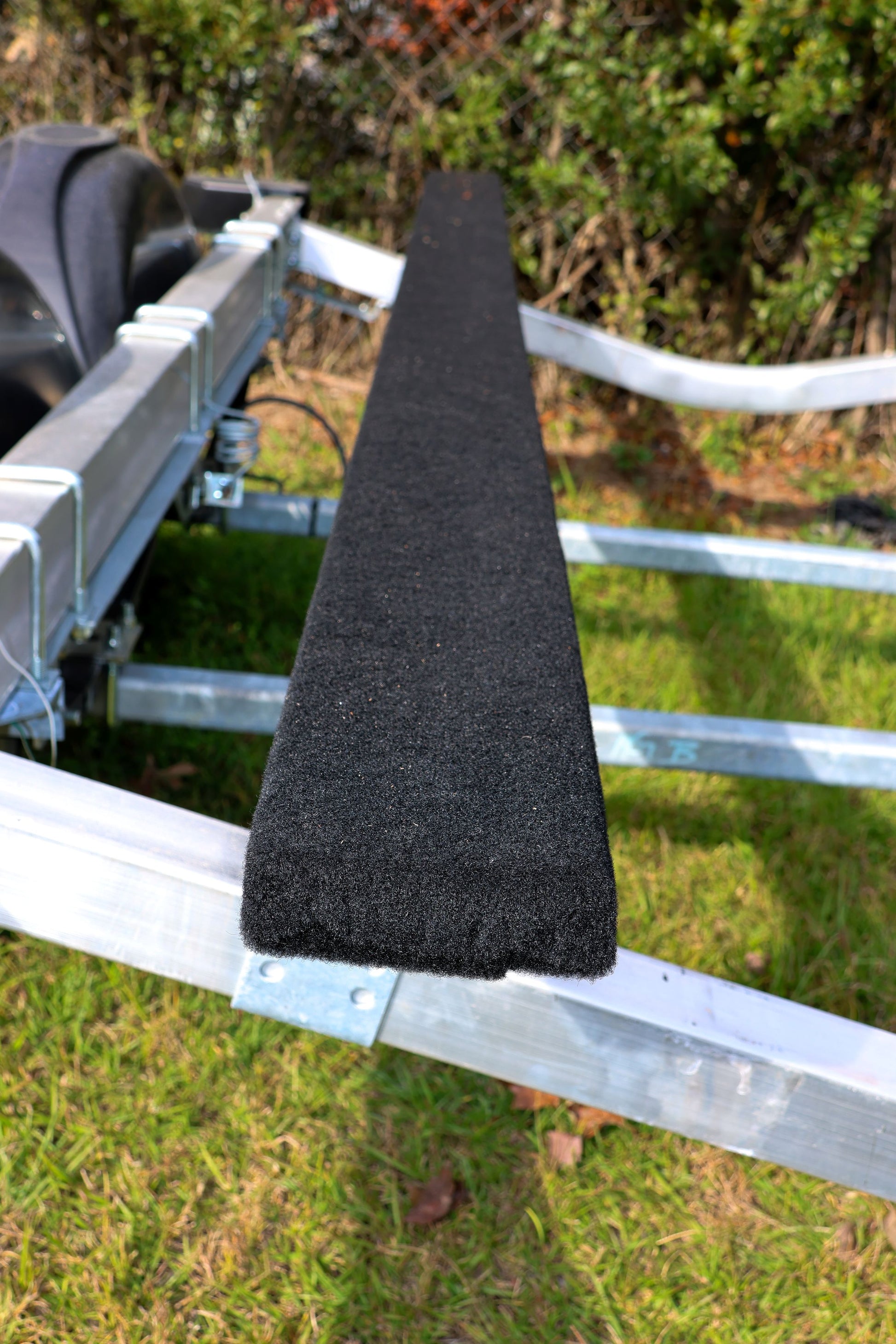 EZ Loader boat trailer with newly installed black marine bunk carpet wrapped around 2×6 bunks, showing clean fit and hull-protection surface